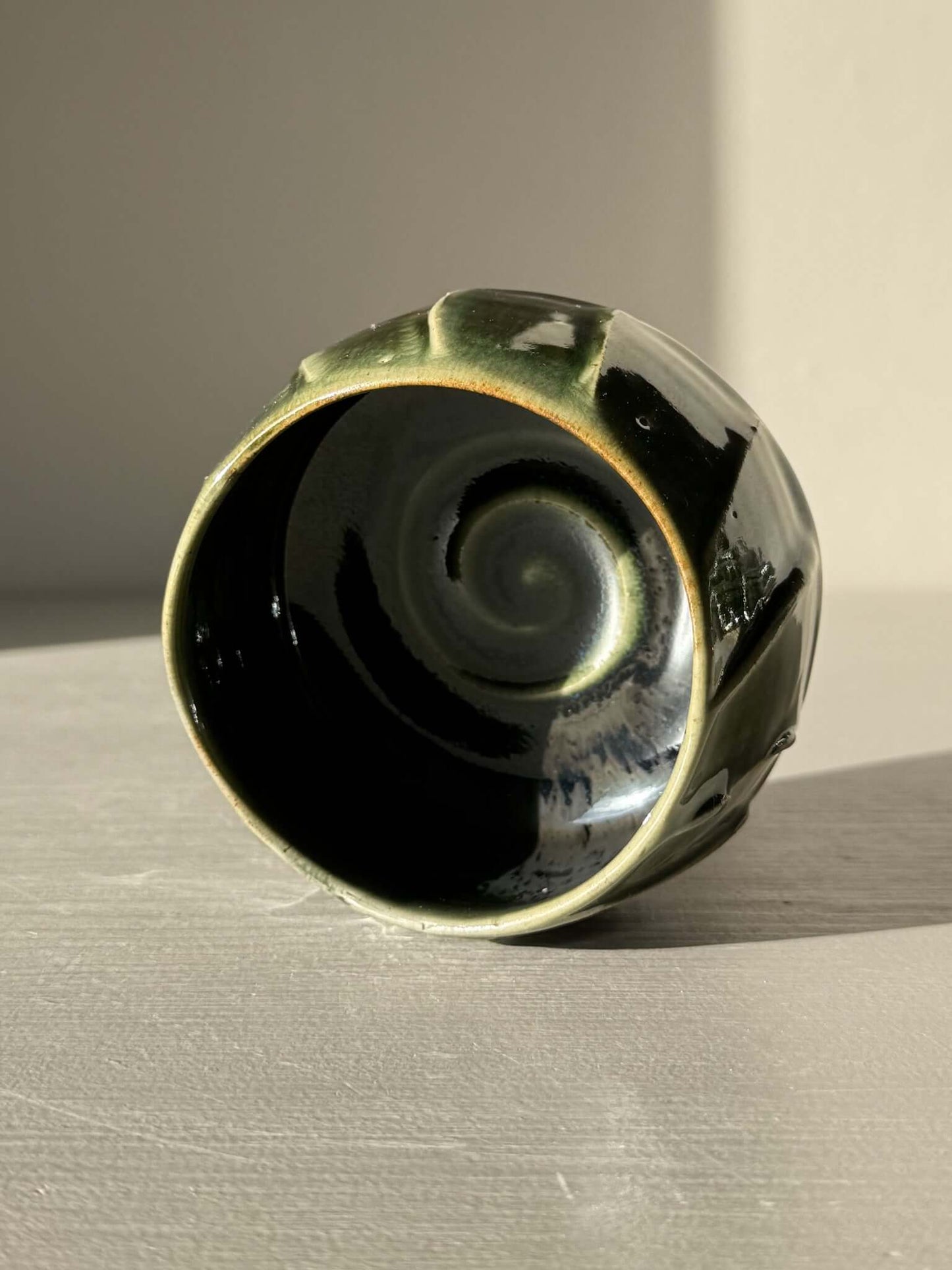 Yunomi Cup - Hinoki #26 with deep green glaze and flowing slip patterns on display