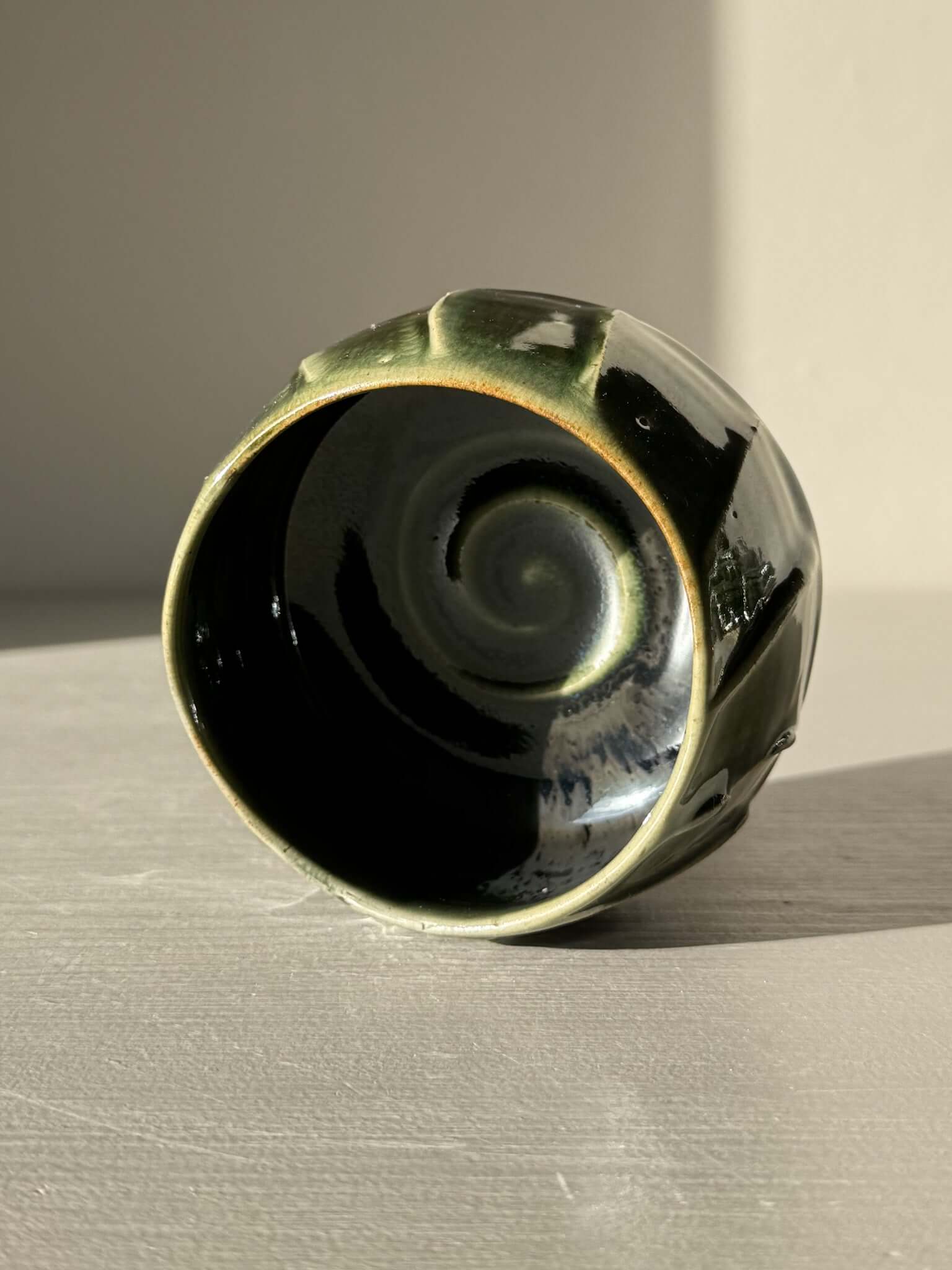 Yunomi Cup - Hinoki #26 with deep green glaze and flowing slip patterns on display