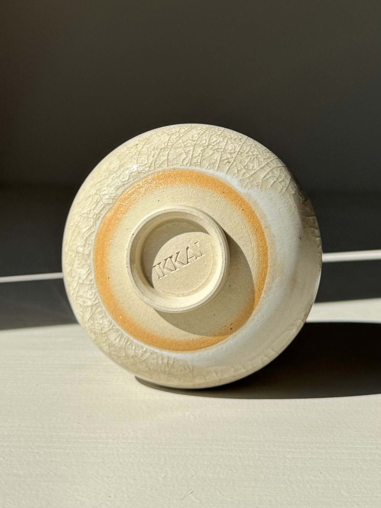 Bottom view of Yunomi Cup - Kannyū Series #01, showcasing handmade ceramic with transparent crackle glaze and fine line patterns.