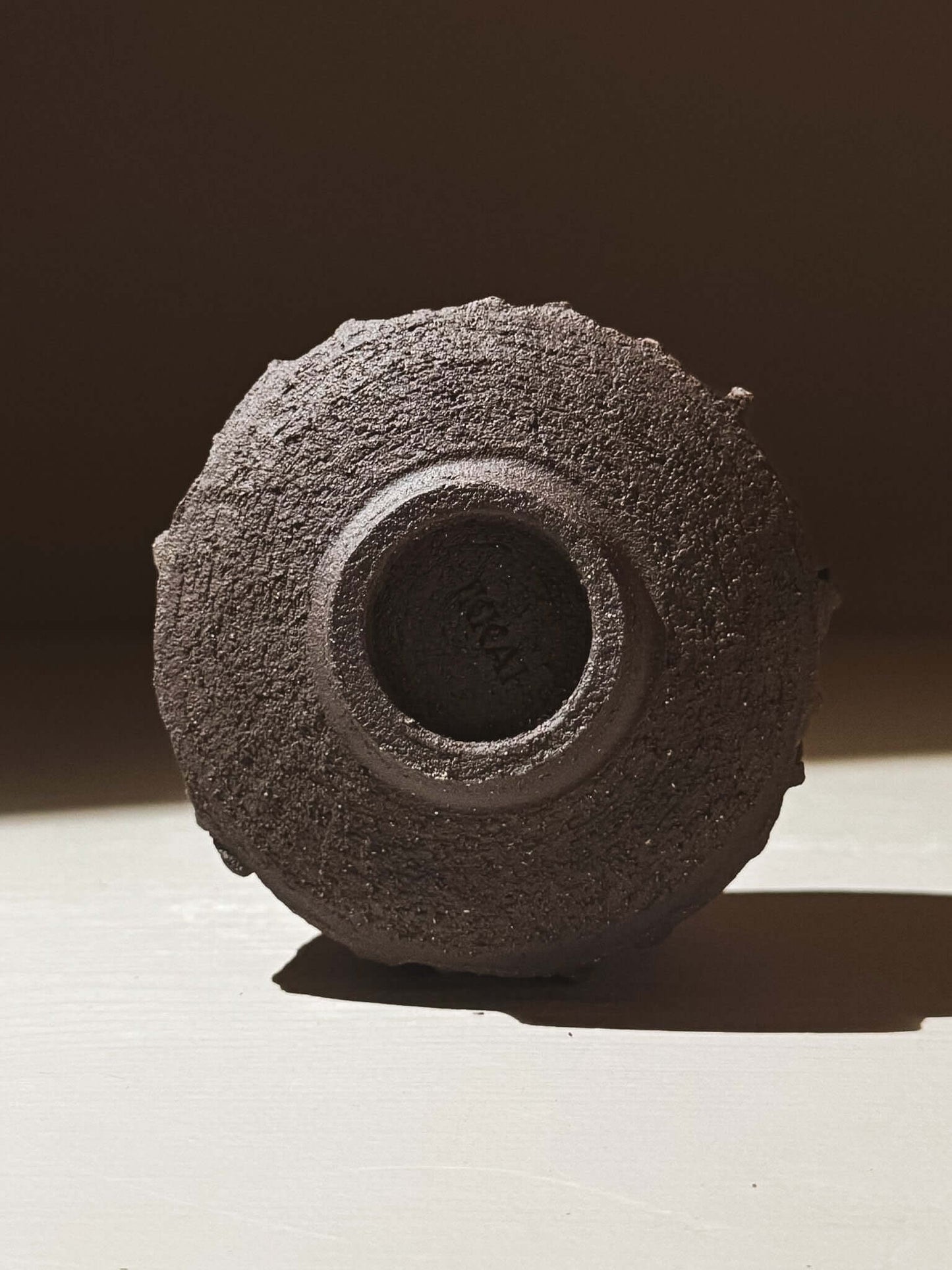Yunomi Cup - Kuro #03 showing the textured dark brown clay exterior from the bottom view.